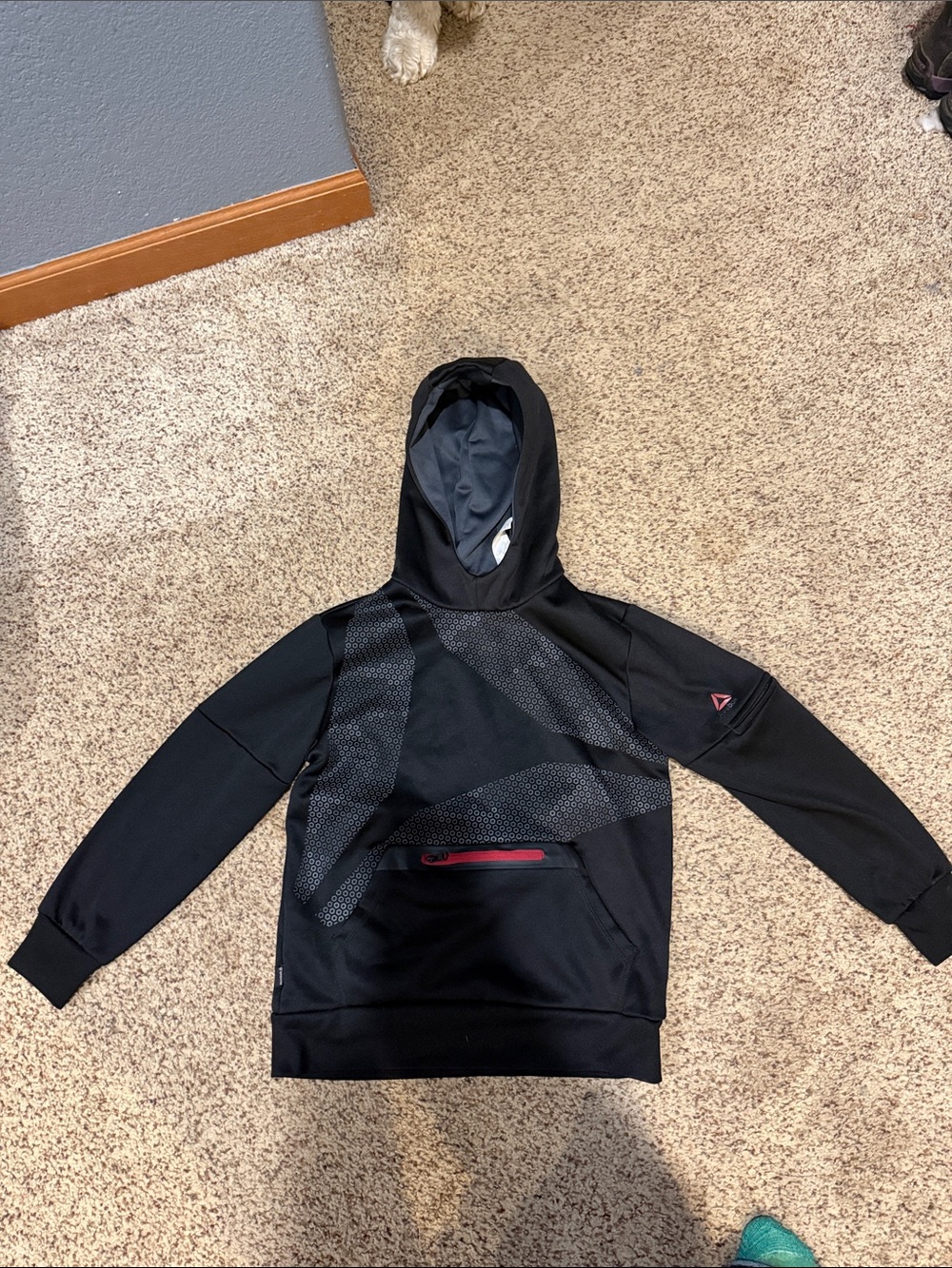 Reebok Black Kids Hoodie with Subtle Pattern and Red Zip Accent